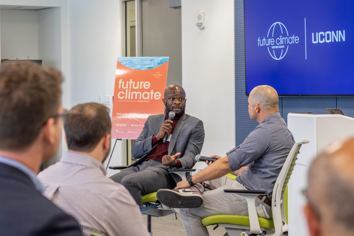 Onyeka Obiocha, left, executive director of CTNext, chats with Cody Simms of MCJ Collective during the Future Climate Venture Studio showcase in the Innovation Partnership Building on April 20, 2023. (Sydney Herdle/UConn Photo)