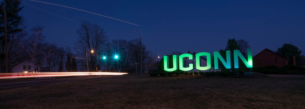 Entryway sign lit up green for St. Patricks Day and for Sustainability. March 16, 2022. (Sean Flynn/UConn Photo)