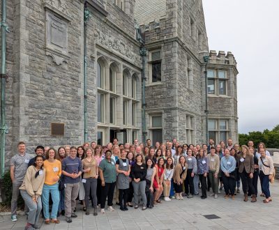 80 people smiling in a group photo on UConn's Avery Point campus