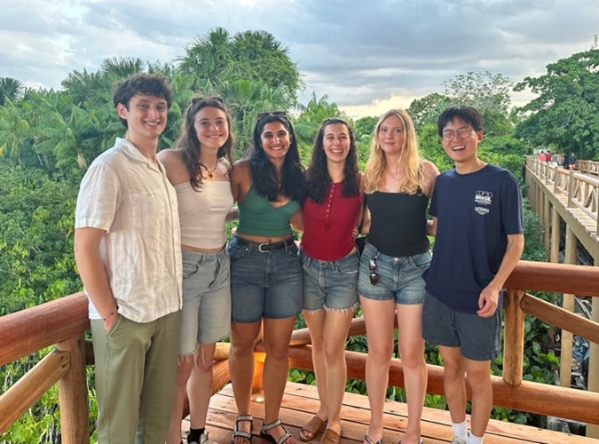 6 students smiling on a canopy walk