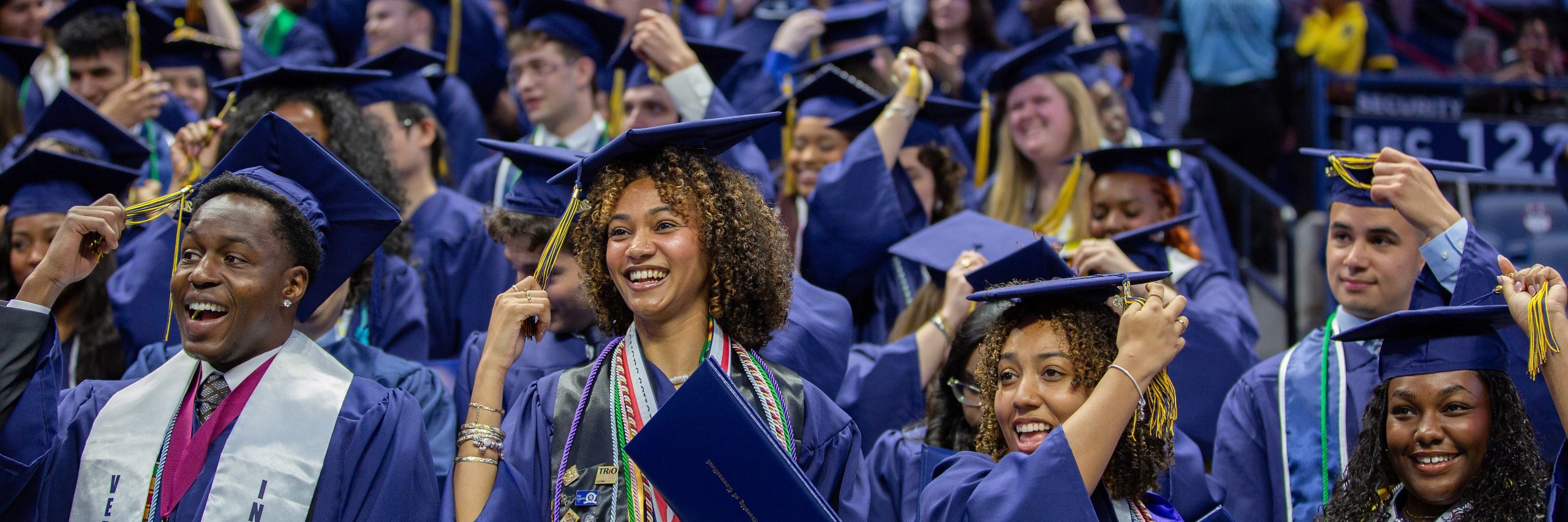 Group of graduates in caps and gowns celebrating at the College of Liberal Arts and Sciences undergraduate commencement ceremony II in Gampel Pavilion on Sunday, May 10, 2026
